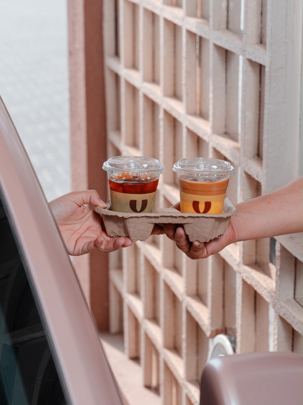 Two drinks handed out of the drive-thru window