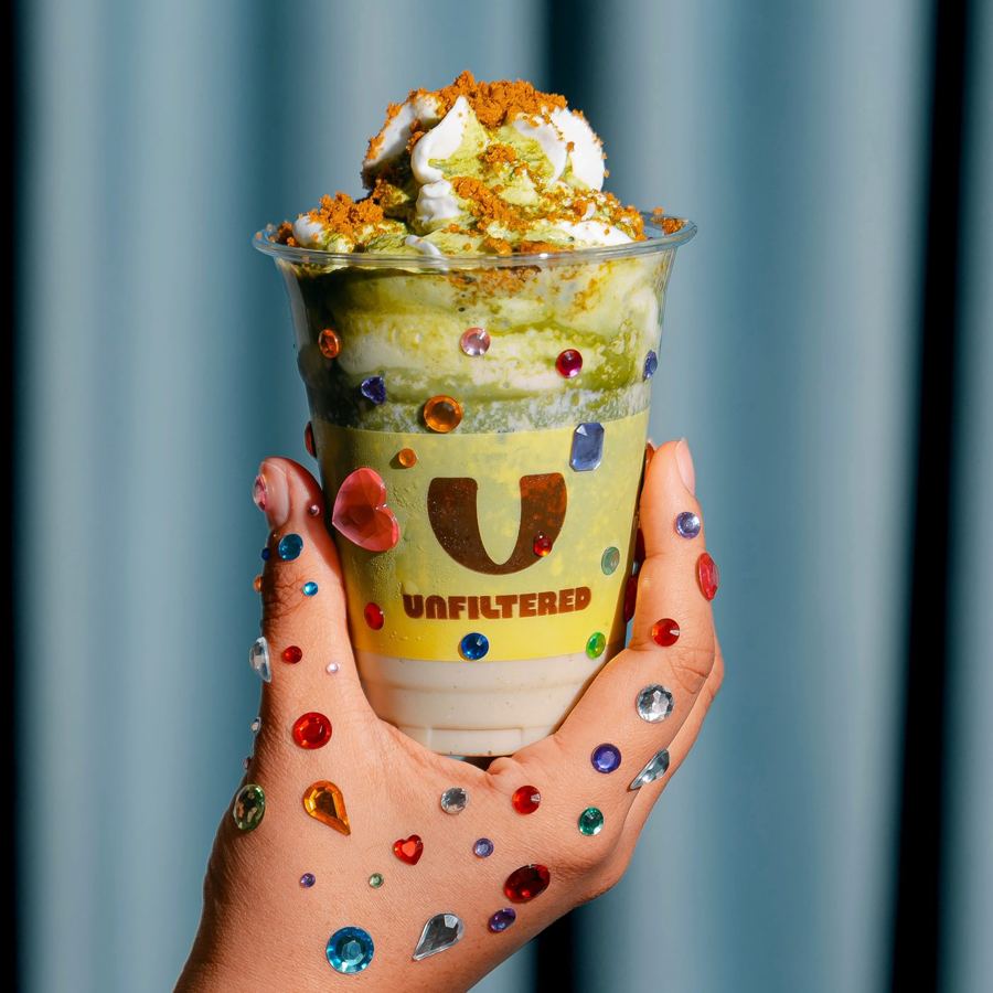 A jewelled hand holding a matcha